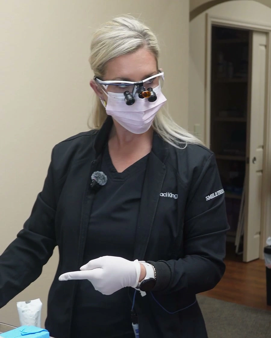 Dr. Traci King wearing her clinical jacket and dental loupes